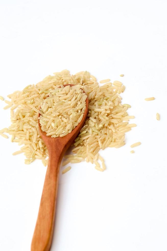 Brown rice on wooden spoon with white background. photo