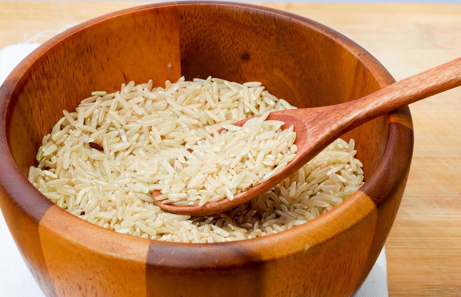 brown rice on wooden bowl, close up, top view. photo