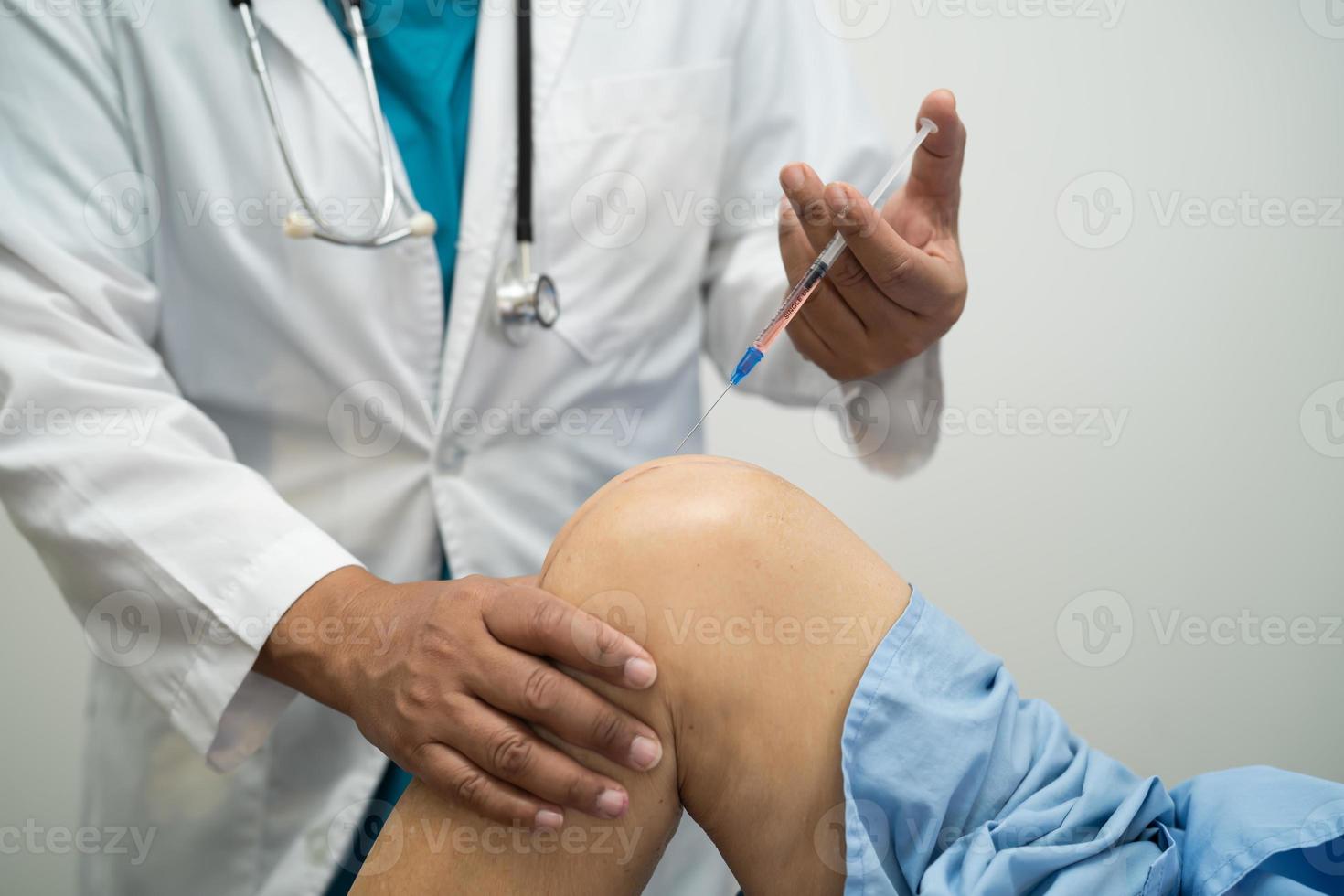 Asian doctor inject Hyaluronic acid platelet rich plasma into the knee of senior woman to walk without pain. photo