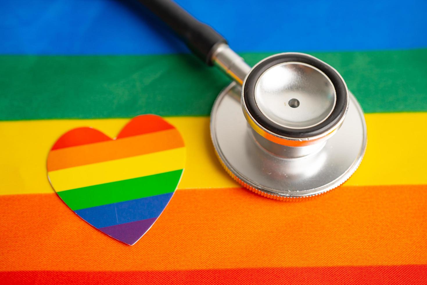 Stethoscope on rainbow flag background, symbol of LGBT pride month celebrate annual in June social, symbol of gay, lesbian, bisexual, transgender, human rights and peace. photo