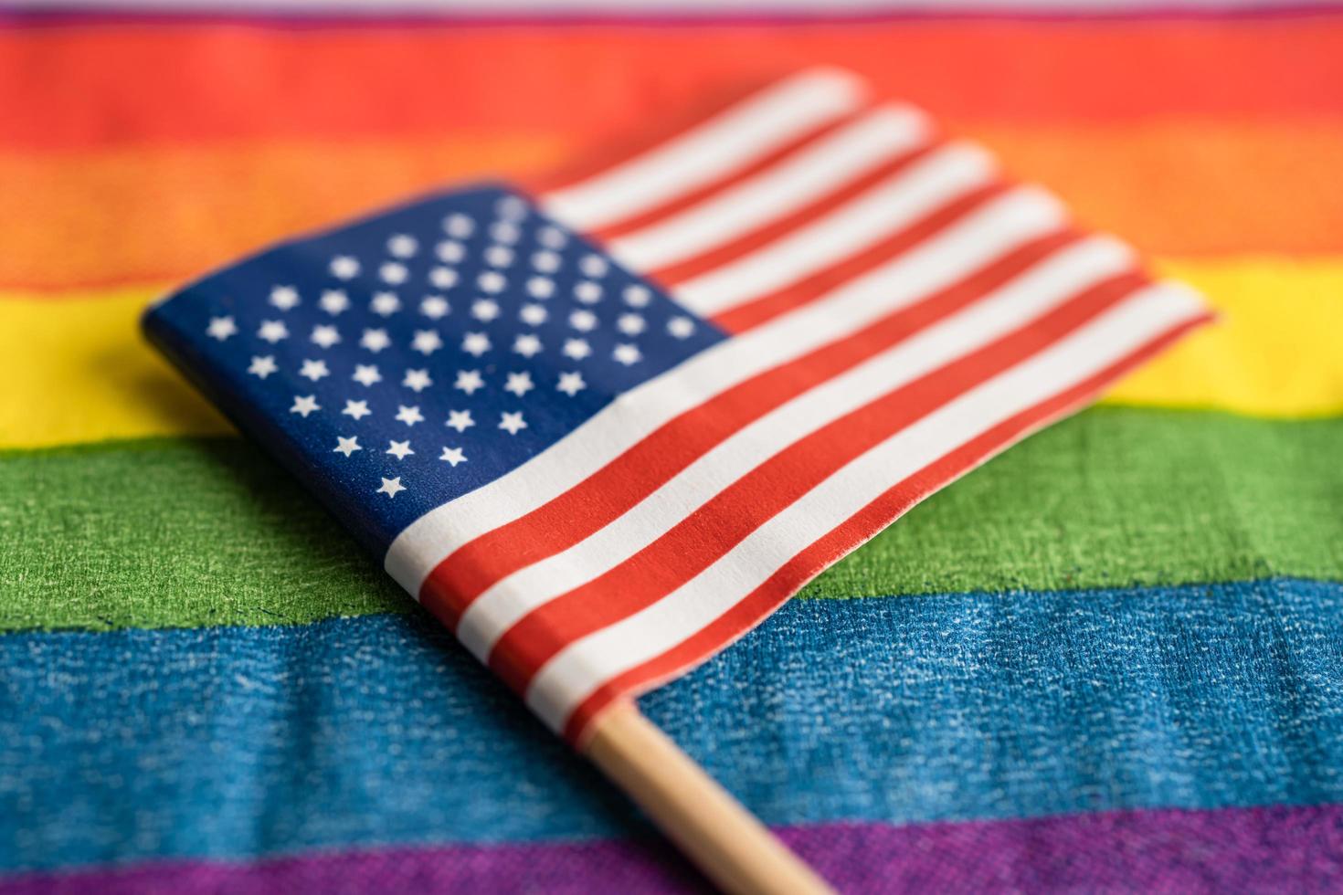 USA America flag on rainbow background symbol of LGBT gay pride month  social movement rainbow flag is a symbol of lesbian, gay, bisexual, transgender, human rights, tolerance and peace. photo