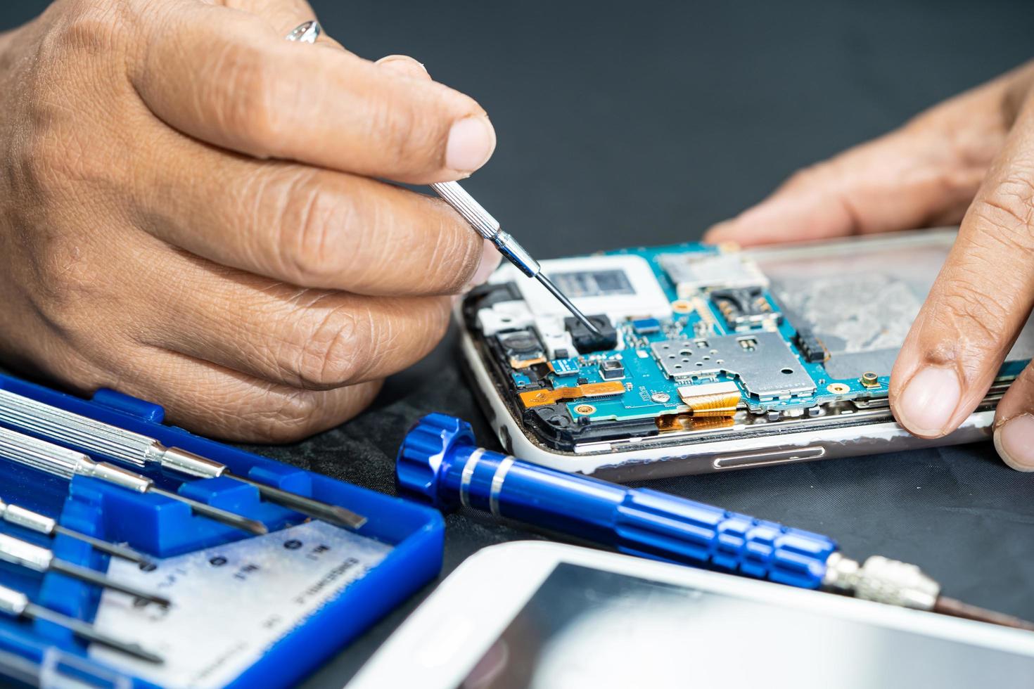 Technician repairing inside of mobile phone by soldering iron. Integrated Circuit. the concept of data, hardware, technology. photo