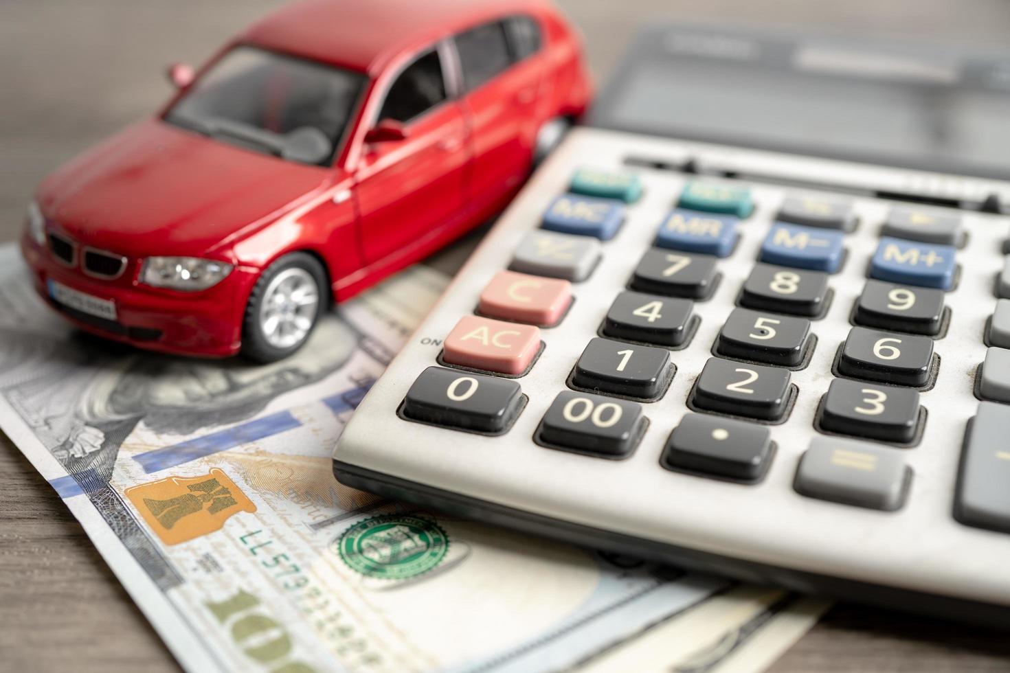 Car on US dollar banknotes and calculator, loan, Finance, saving money, insurance and leasing time concepts. photo