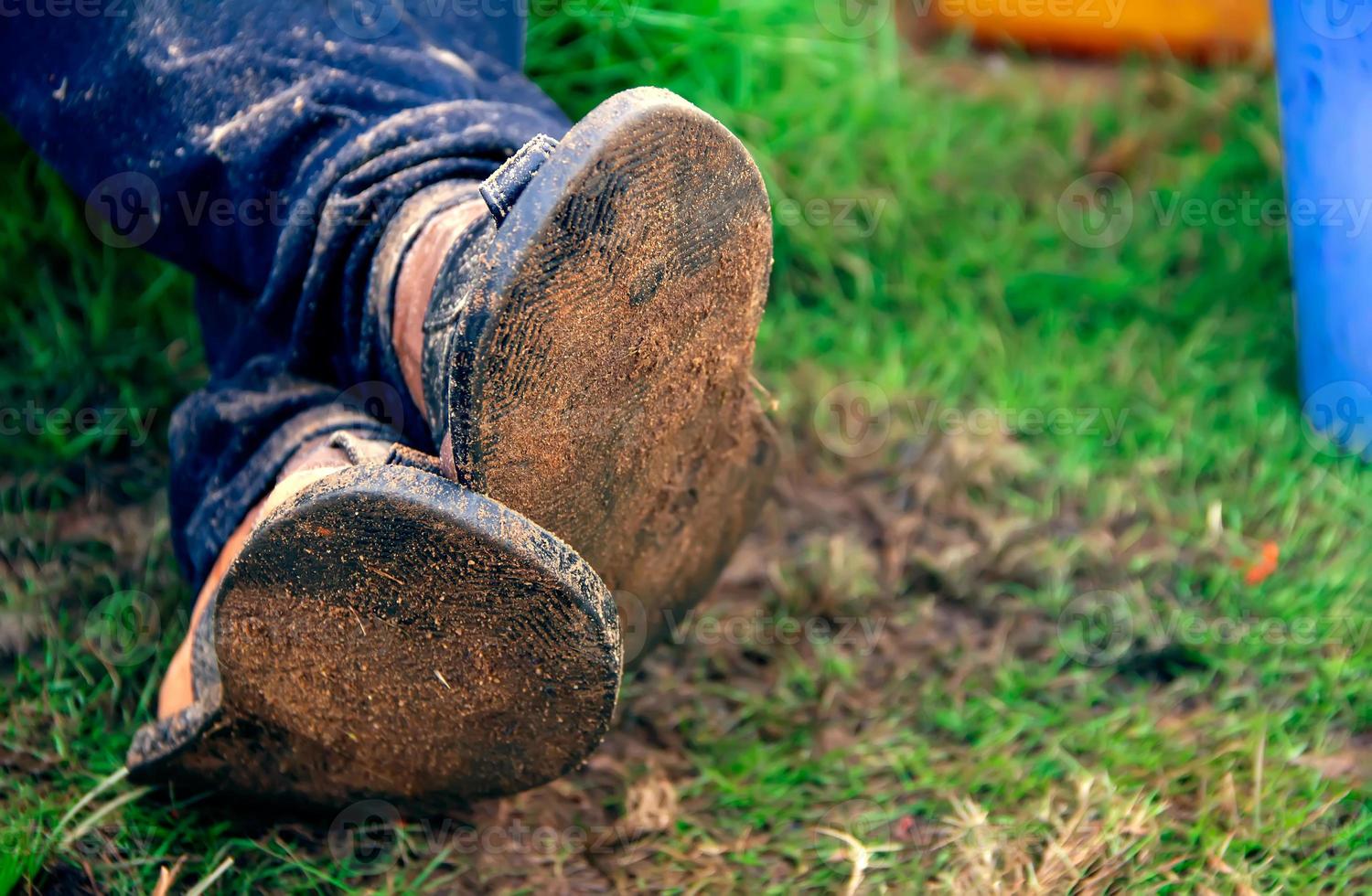 feet of a person crossed and resting on a green grass. Crossed legs on the ground photo