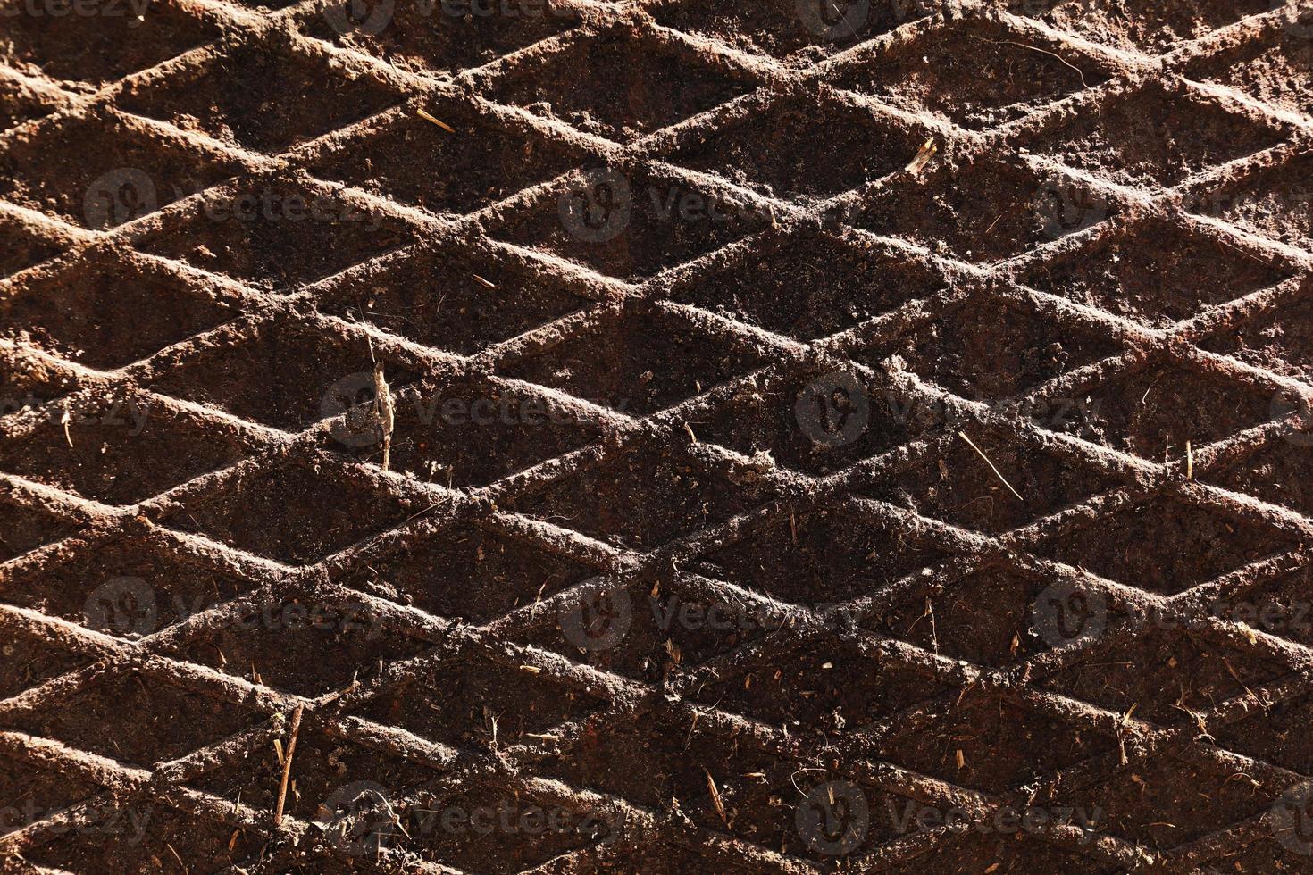 Canal cover surface texture. Rusty iron square pattern. Rusty metal square texture. Robust old iron rusted canal cover wallpaper. Ruststained canal grid form cover backdrop. photo