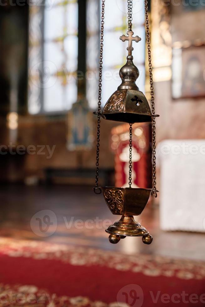 selective focus. A priest's censer hangs on an old wall in the Orthodox Church. Copper incense with burning coal inside. Service in the concept of the Orthodox Church. Adoration photo