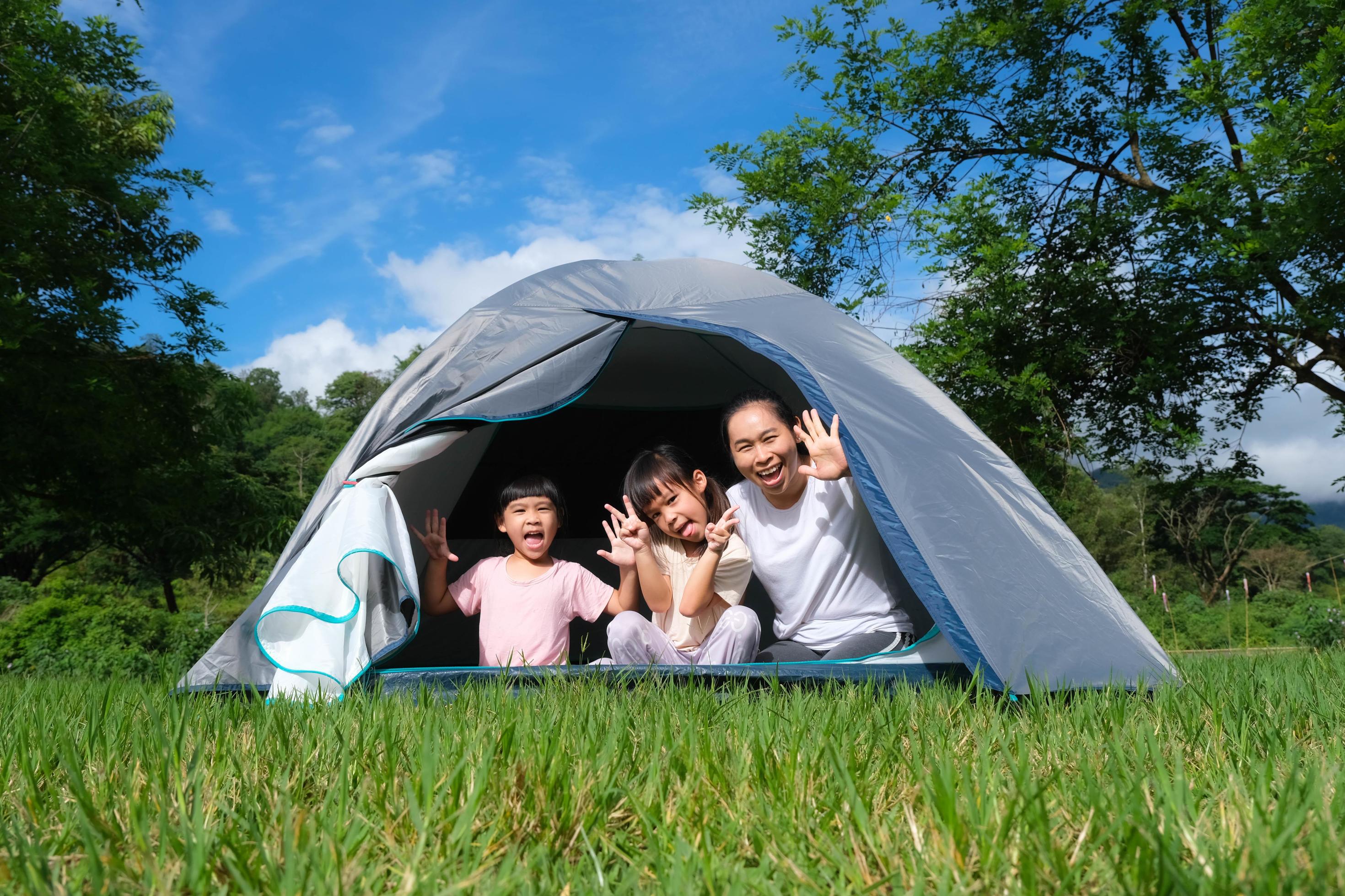 Sisters spending time in a tent on camping. Children using tablet playing games  online during summer vacation - a Royalty Free Stock Photo from Photocase