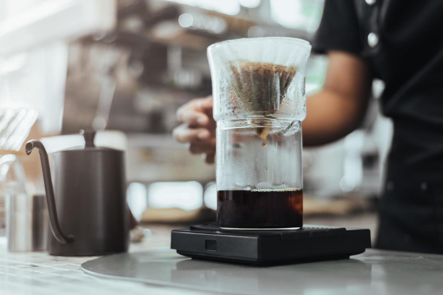 barista haciendo café vertiéndolo en la cafetería cerca de las