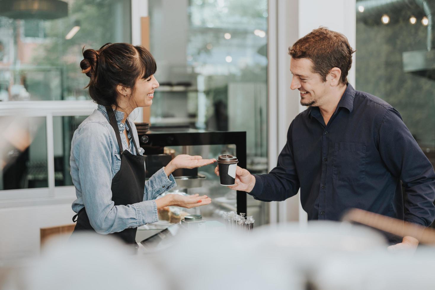 Caucasian woman barista take order from customer in coffee shop. female barista using digital tablet to take order. Coffee owner concept. photo