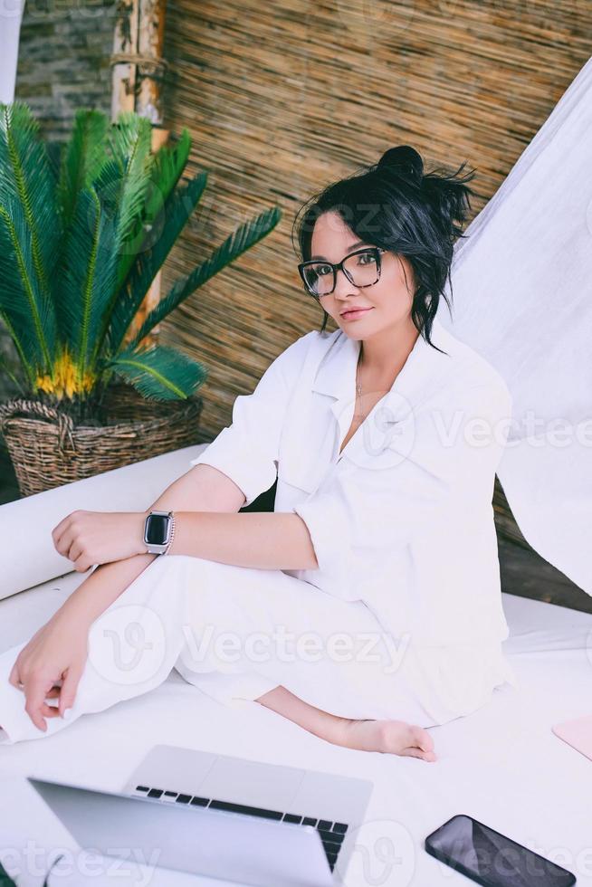 Beautiful woman entrepreneur freelancer in glasses work remotely. Education, travel, business concept photo