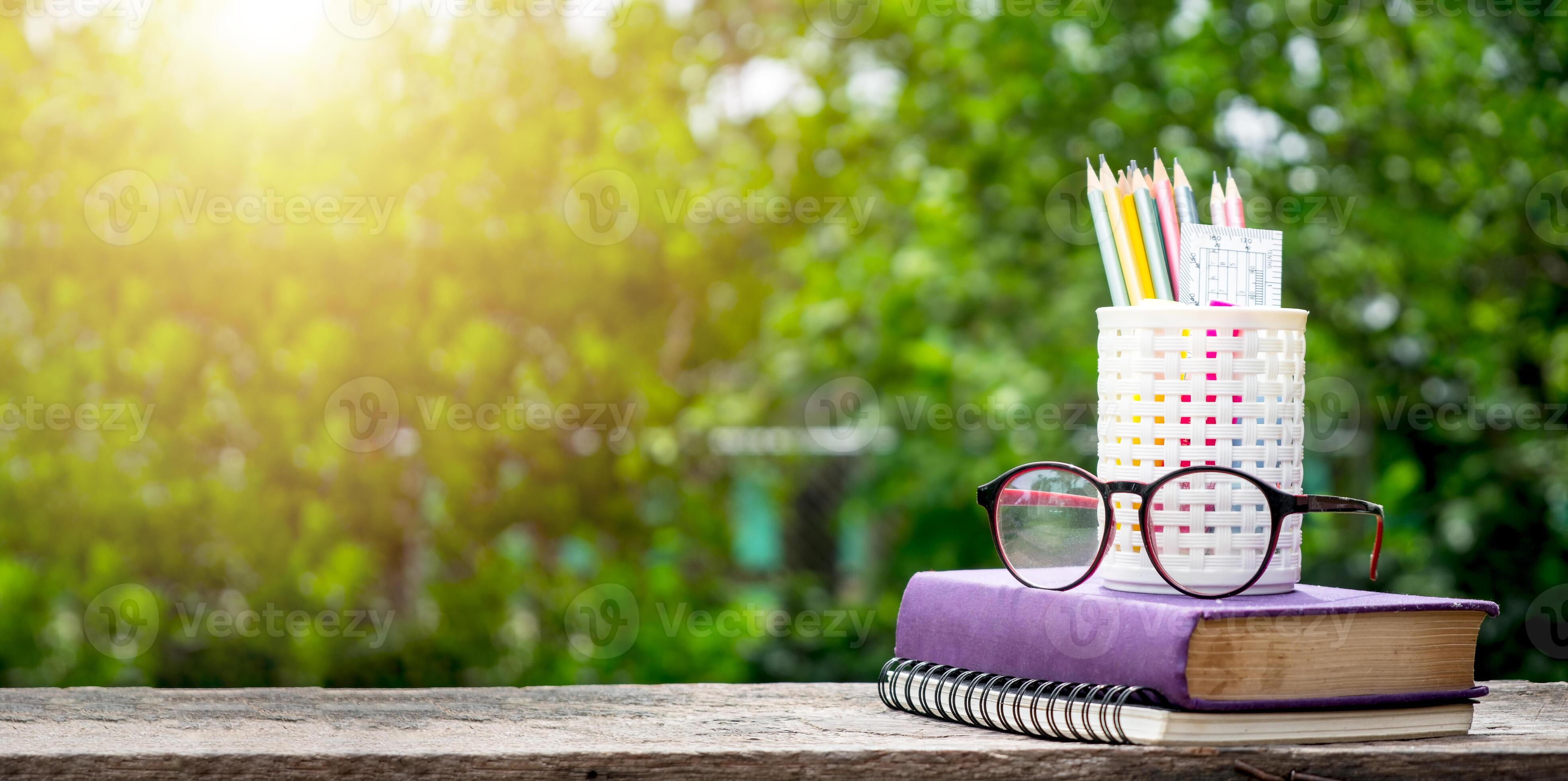 Back to school background with books, pencil and ruler on green blurred
