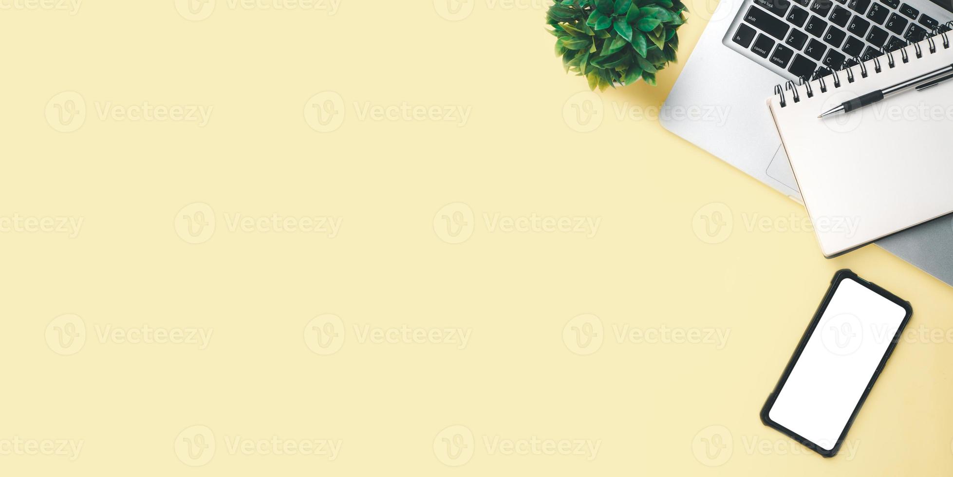 Office desk with computer, Blank screen smart phone, Pen, Notebook on yellow background, Top view with copy space, Mock up. photo