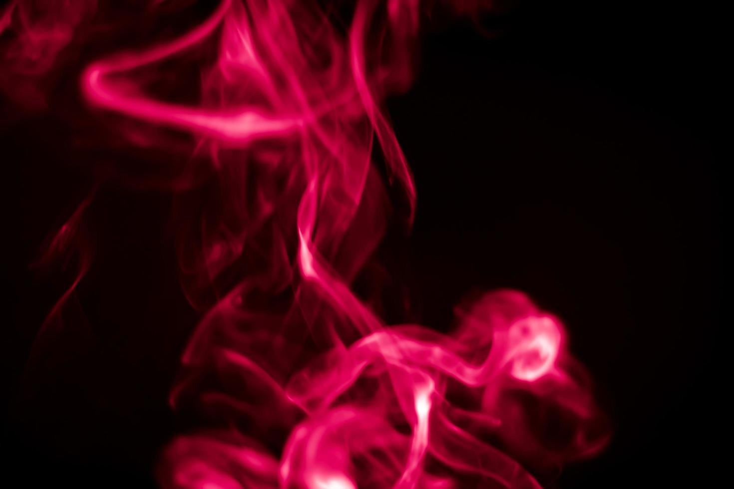 Red smoke in a dark room in a black background photo