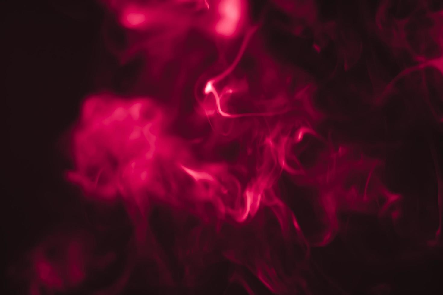 Red smoke in a dark room in a black background photo