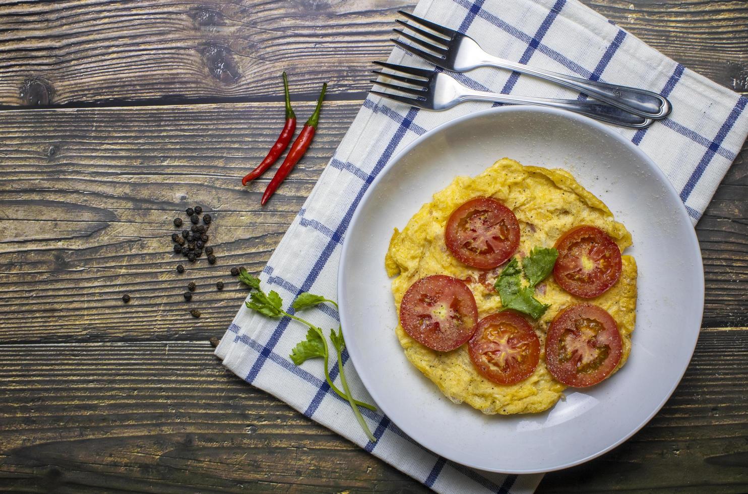 Omelette in a dish that is placed on a wooden background photo