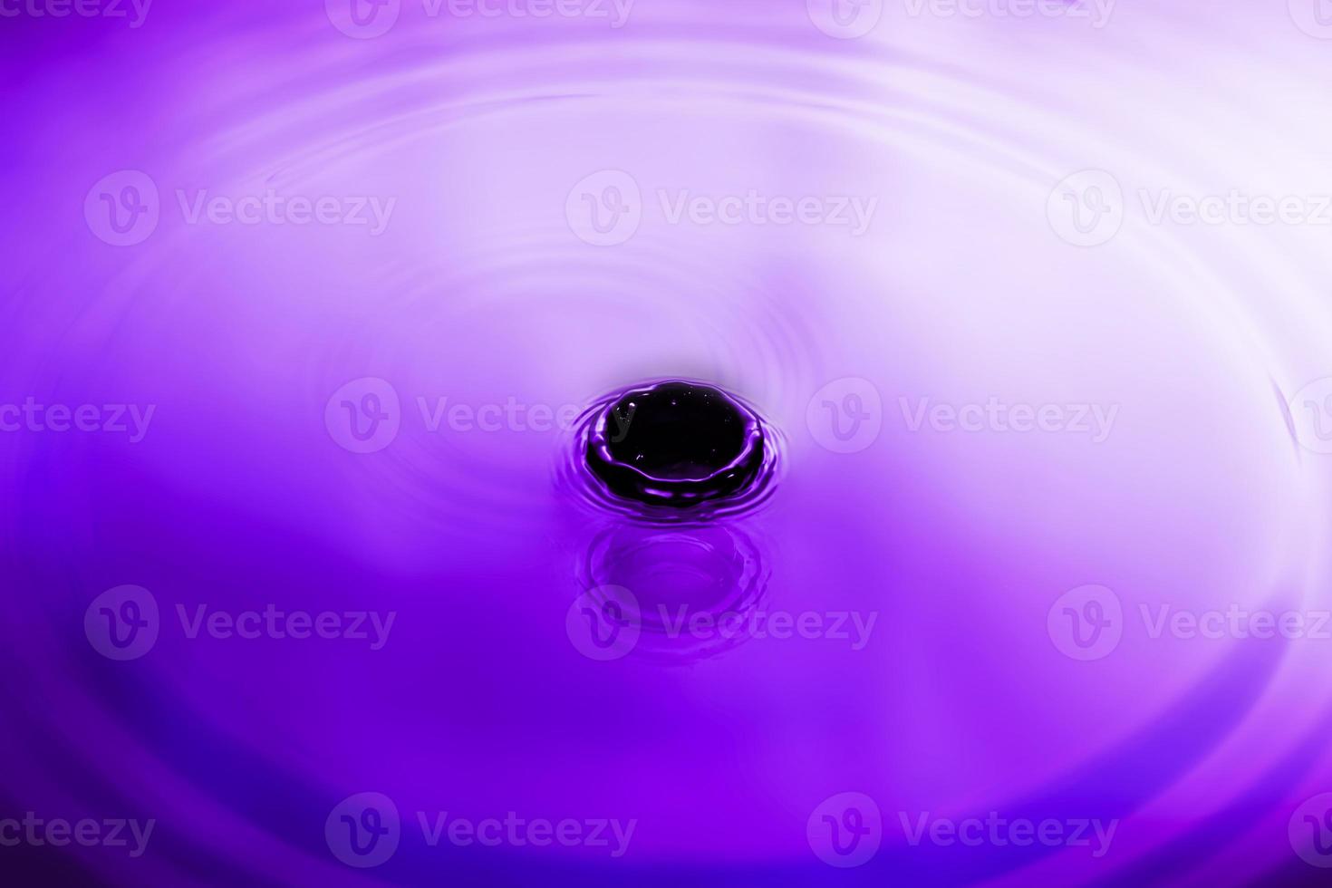 abstract purple splash water The surface of the water spreads in glittering circles. photo