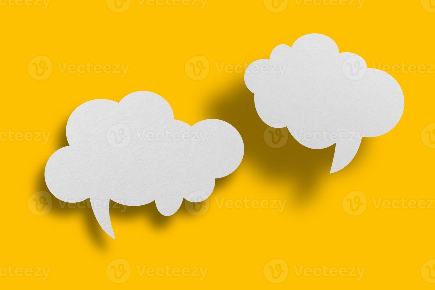 White paper in speech bubble shape set against yellow background. photo