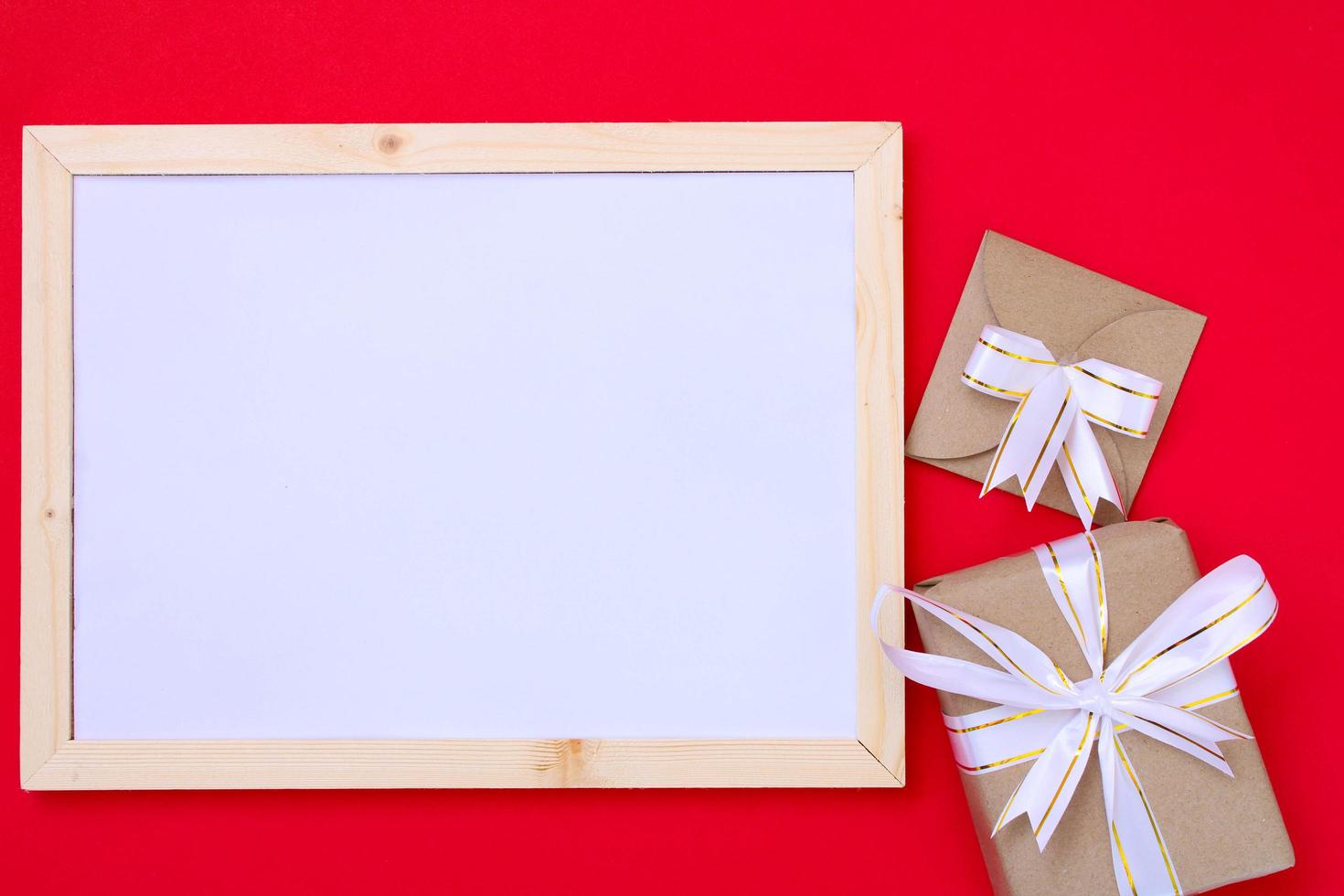 Blank frame and gift box on red ground for Christmas and celebrations. photo