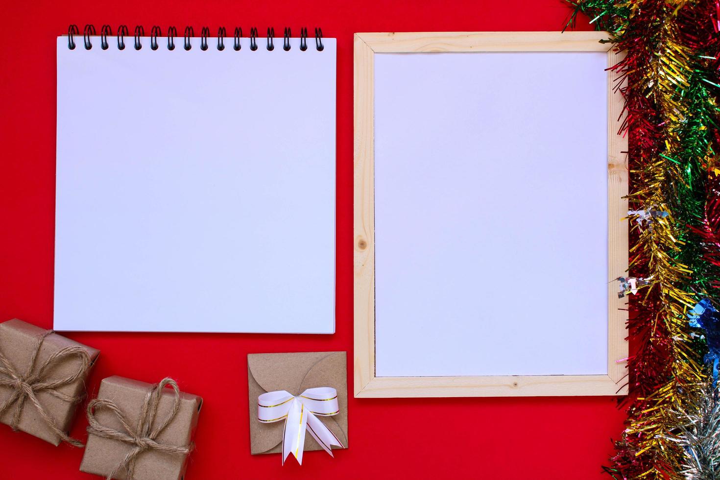 Note book and Christmas gift box on red background. photo
