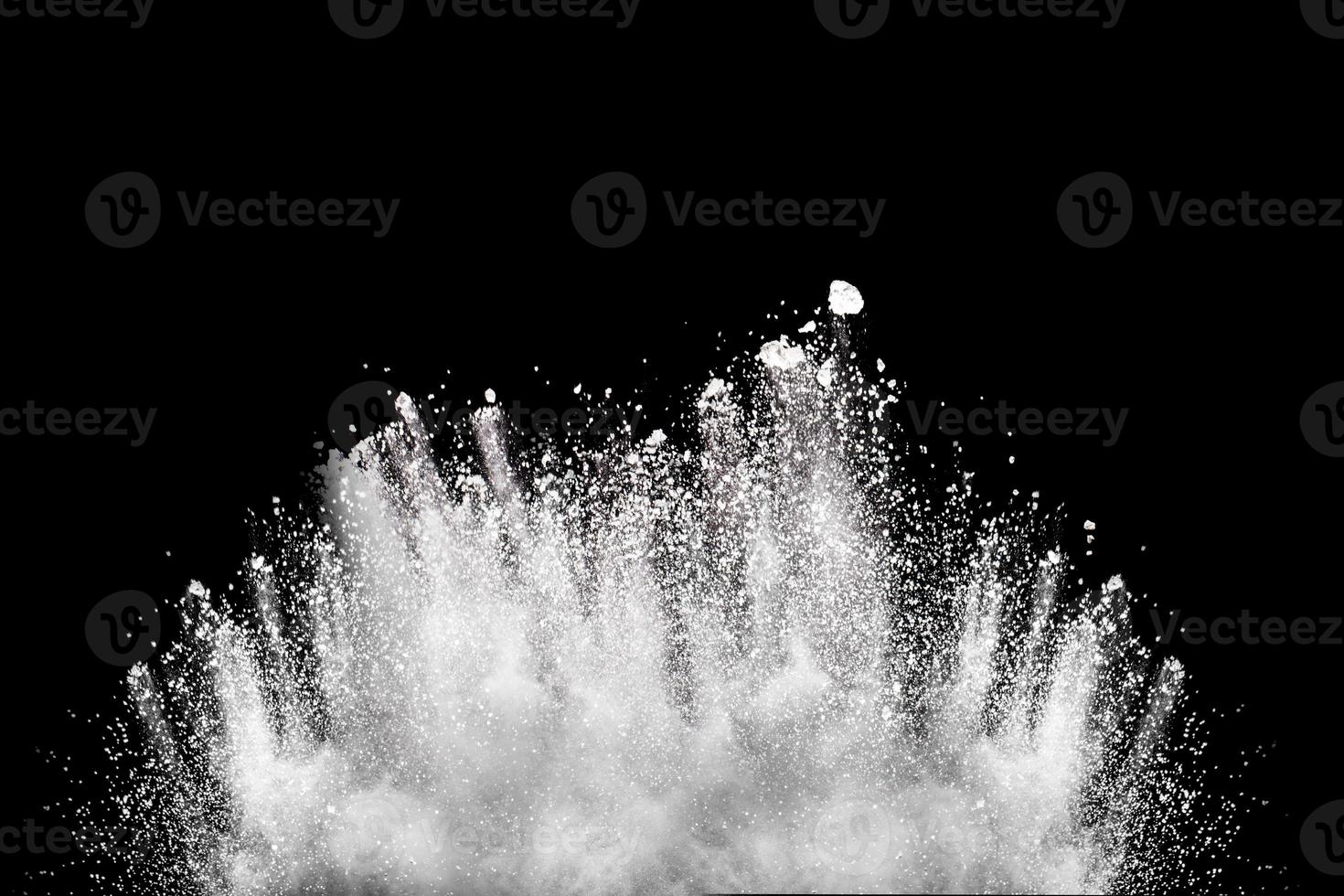 Bizarre forms of white powder explosion cloud against black background.White dust particles splash. photo