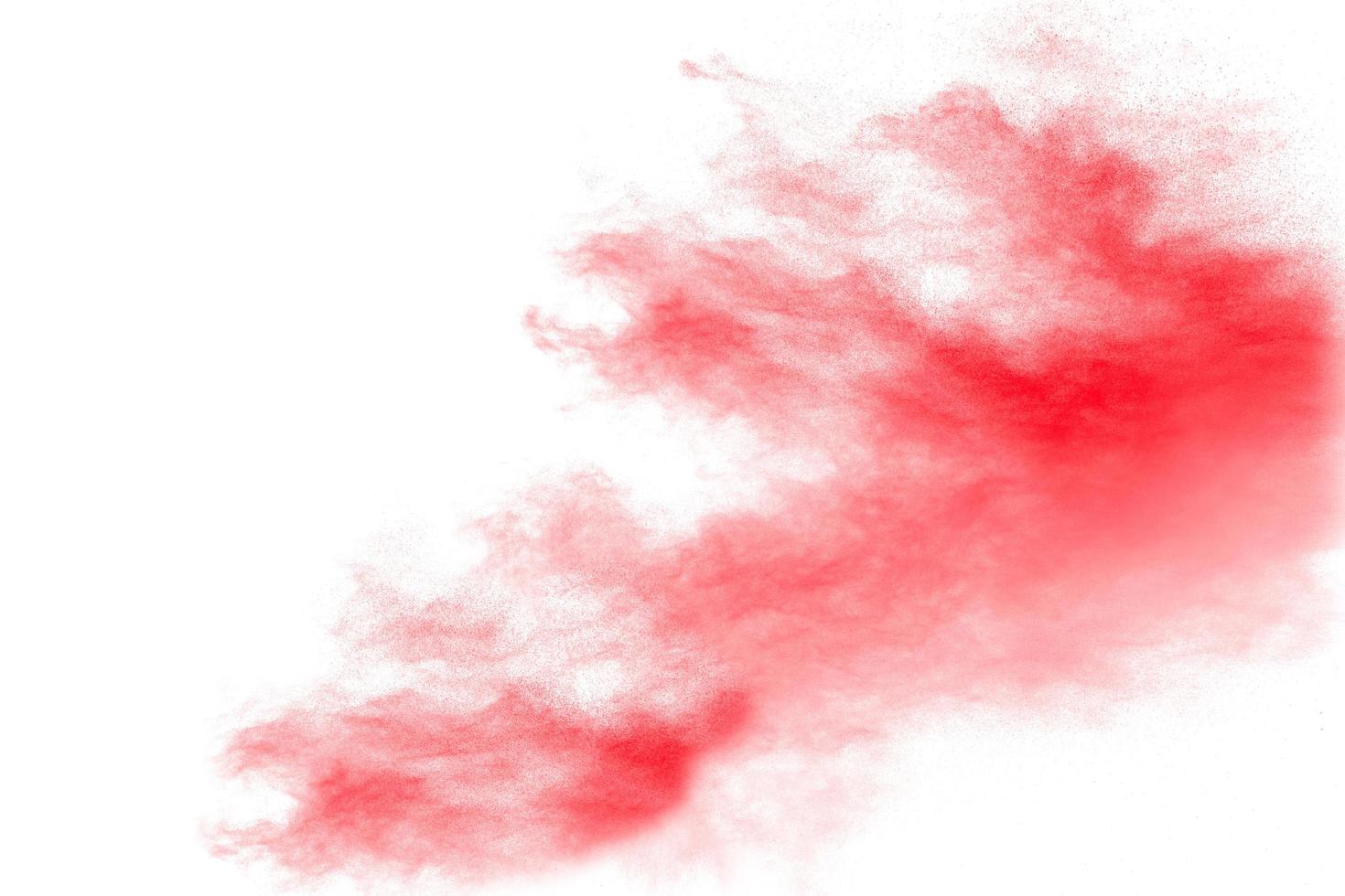 polvo rojo abstracto salpicado sobre fondo blanco. explosión de polvo rojo. movimiento congelado de salpicaduras de partículas rojas. foto