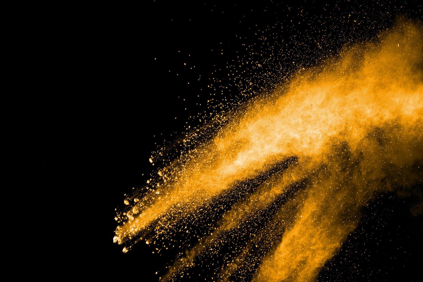 Orange color powder explosion on black background. photo