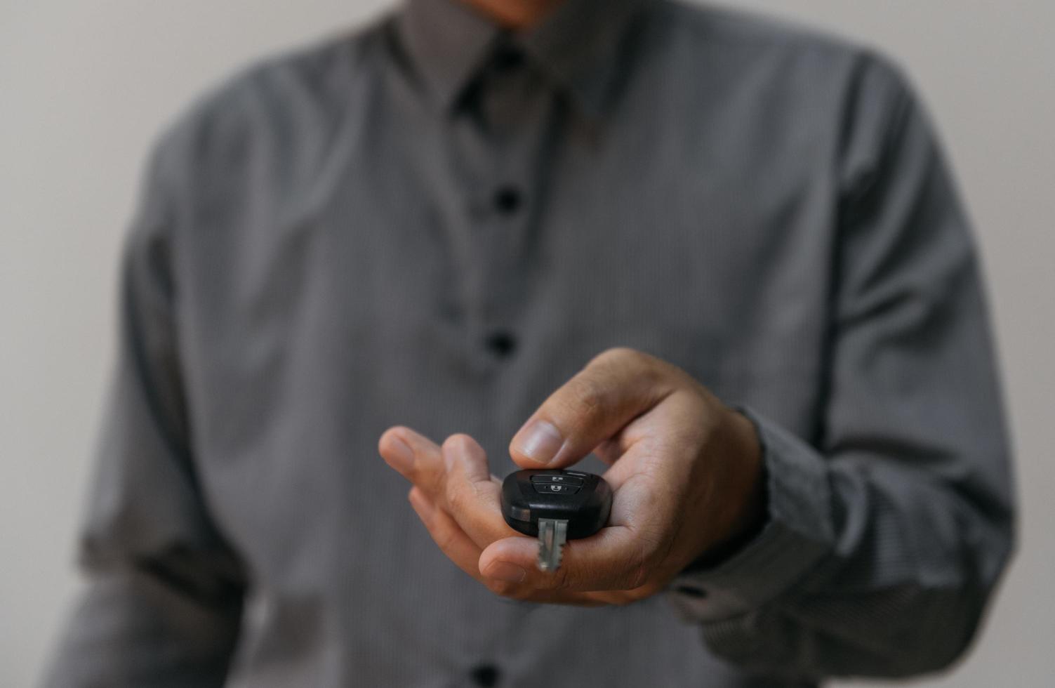 Close up hands holding car keys. man holding key of car giving to agent of Insurance for sell. business investment Insurance Car seizure and car concept. photo