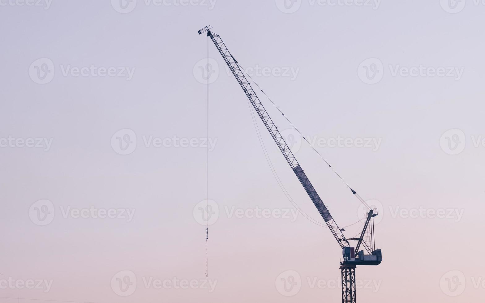 Abstract Industrial background with construction cranes silhouettes over amazing sunset sky photo