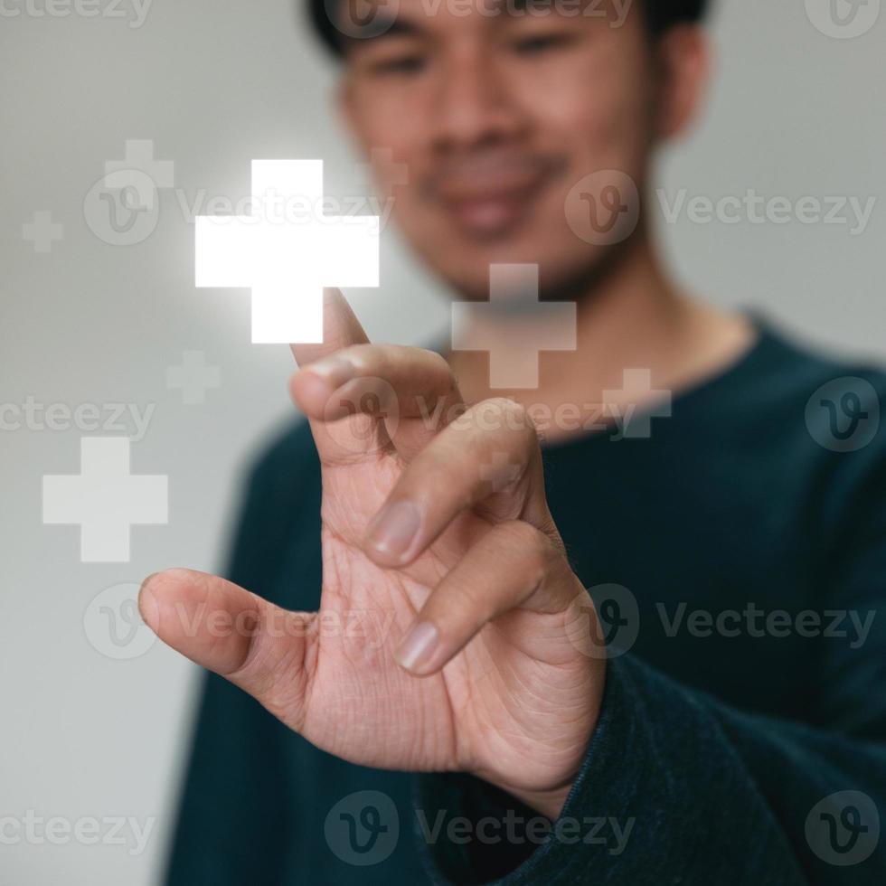 Handsome man touching plus sign icon means to offer positive thing. like benefits, personal development, social network concept photo