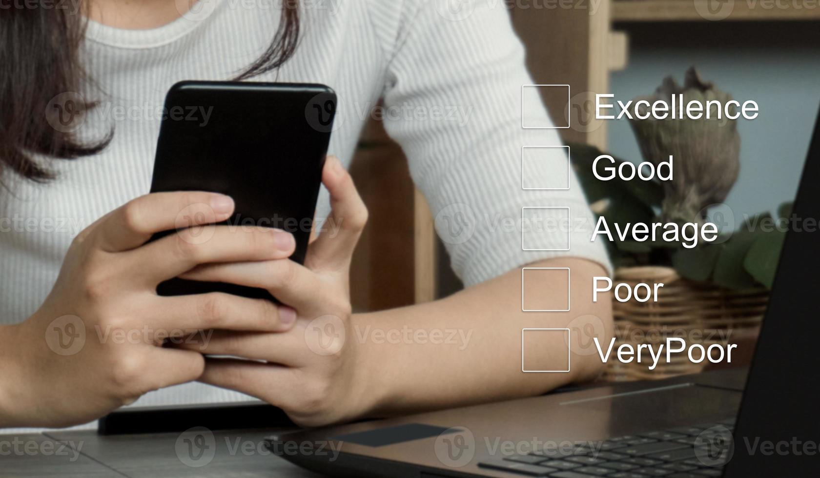 Customer service evaluation concept.Businesswomen hand putting check mark a checkbox on smarthphone for a satisfaction survey. photo