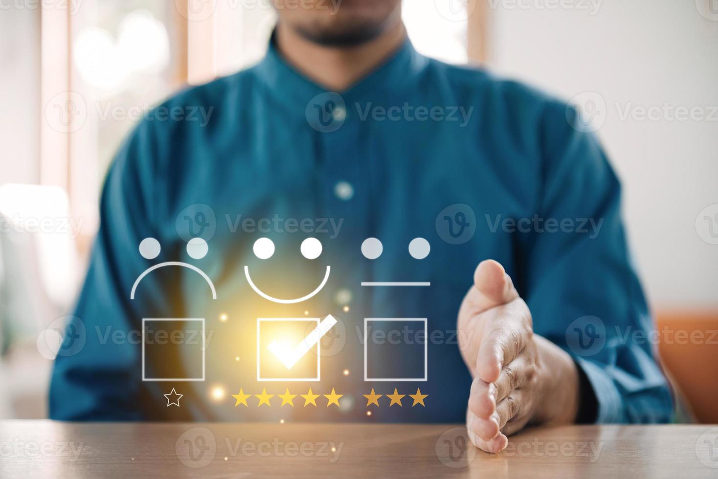 Customer service evaluation concept. Businessman using a smartphone And she is pressing face emoticon smile in satisfaction on virtual touch screen. photo