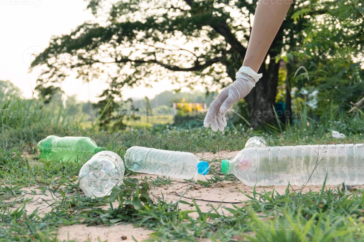 woman hand picking up garbage plastic for cleaning at park photo
