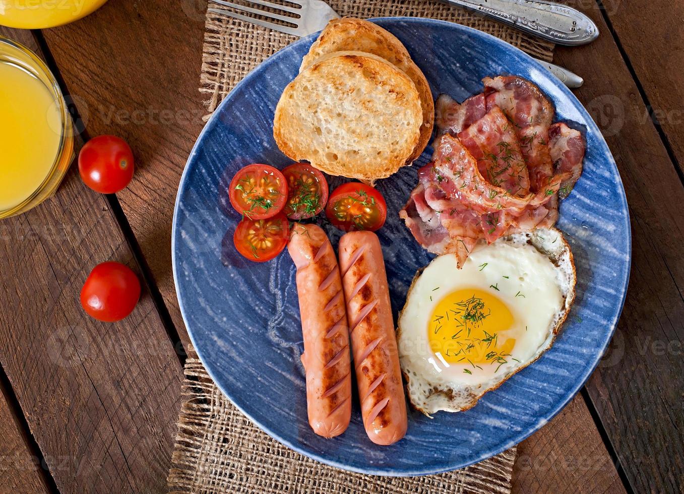 English breakfast - toast, egg, bacon and vegetables in a rustic style on wooden background photo