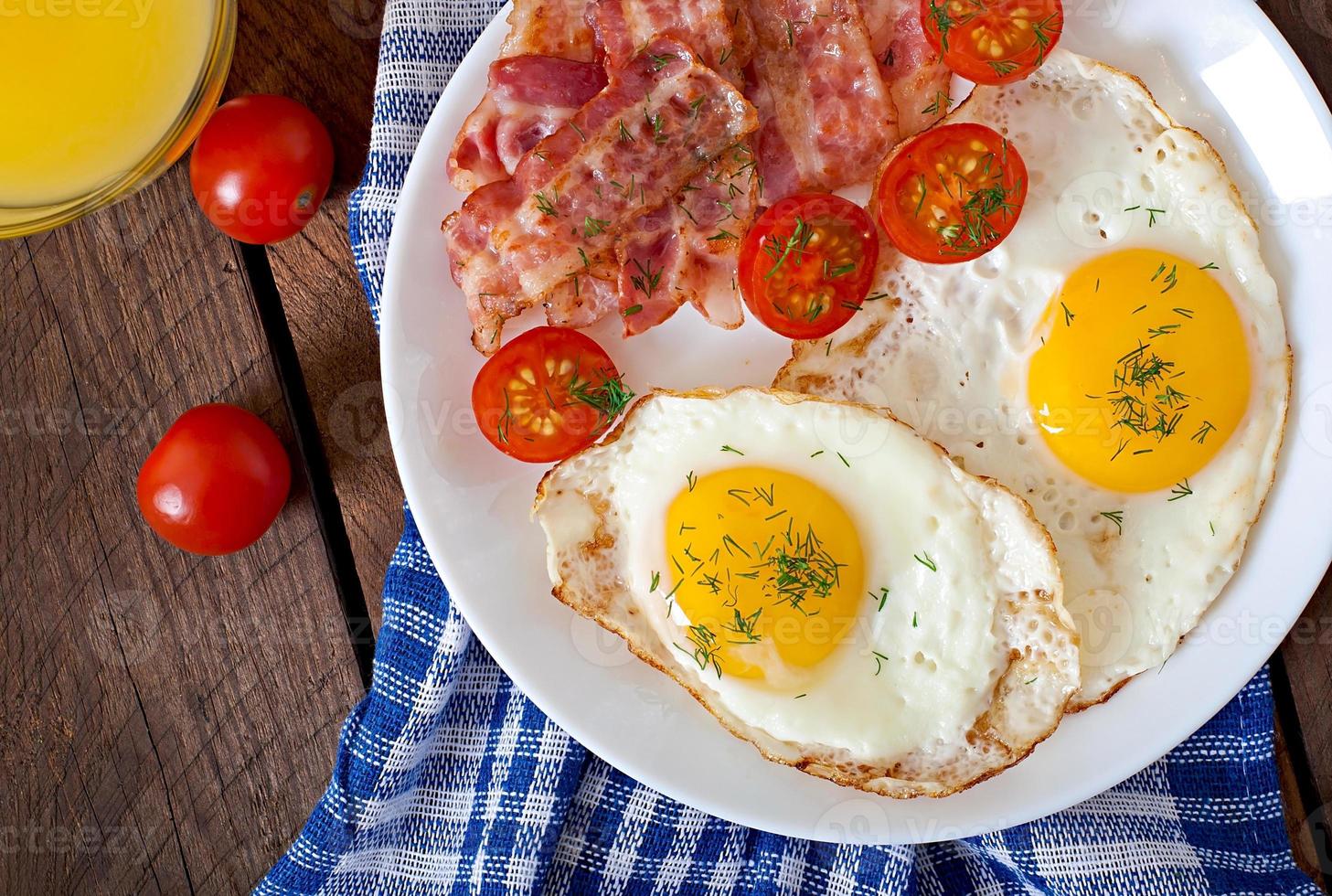 English breakfast - toast, egg, bacon and vegetables in a rustic style on wooden background photo