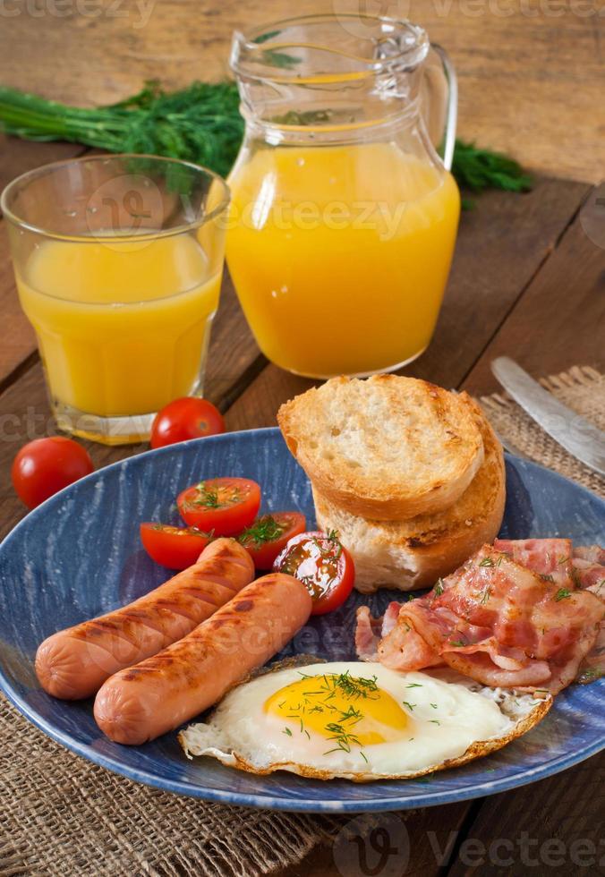 English breakfast - toast, egg, bacon and vegetables in a rustic style on wooden background photo