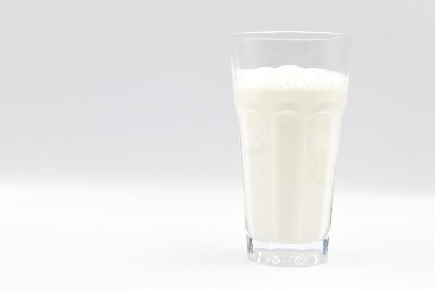 leche en primer plano de vidrio sobre un fondo blanco. foto