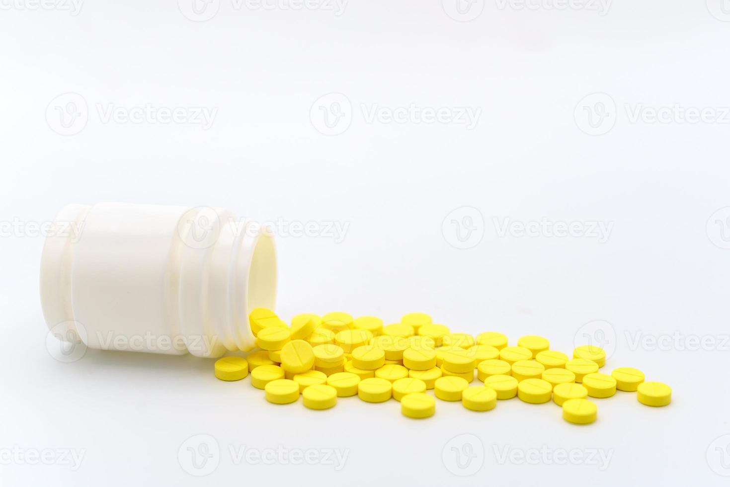 Medical and Healthcare Concept. Closeup of yellow pills with bottle on white background. photo
