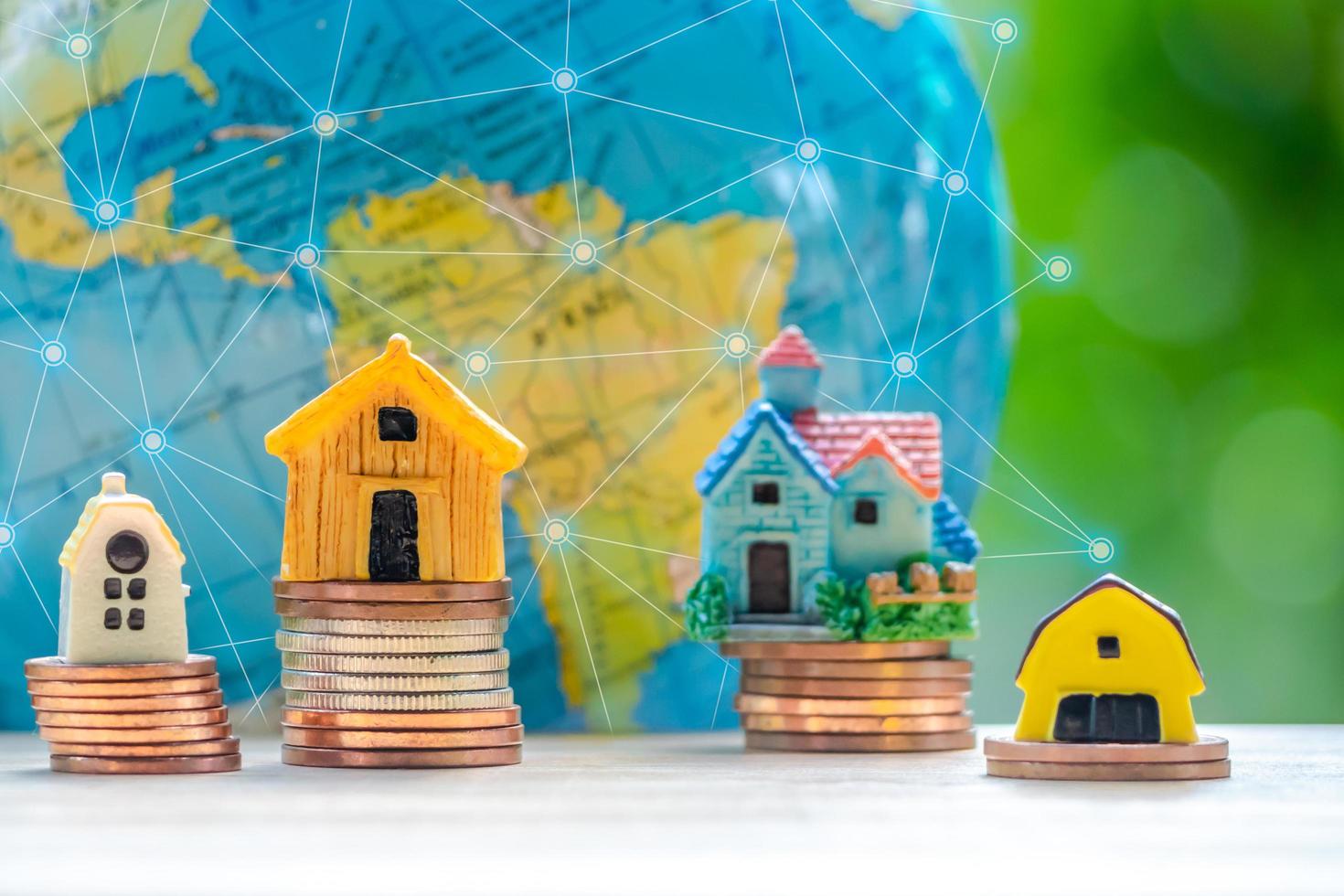 House or Home model with coins stack in front of globe model. Concept for loan, property ladder, financial, mortgage, real estate investment, taxes and bonus. Communication concept. photo