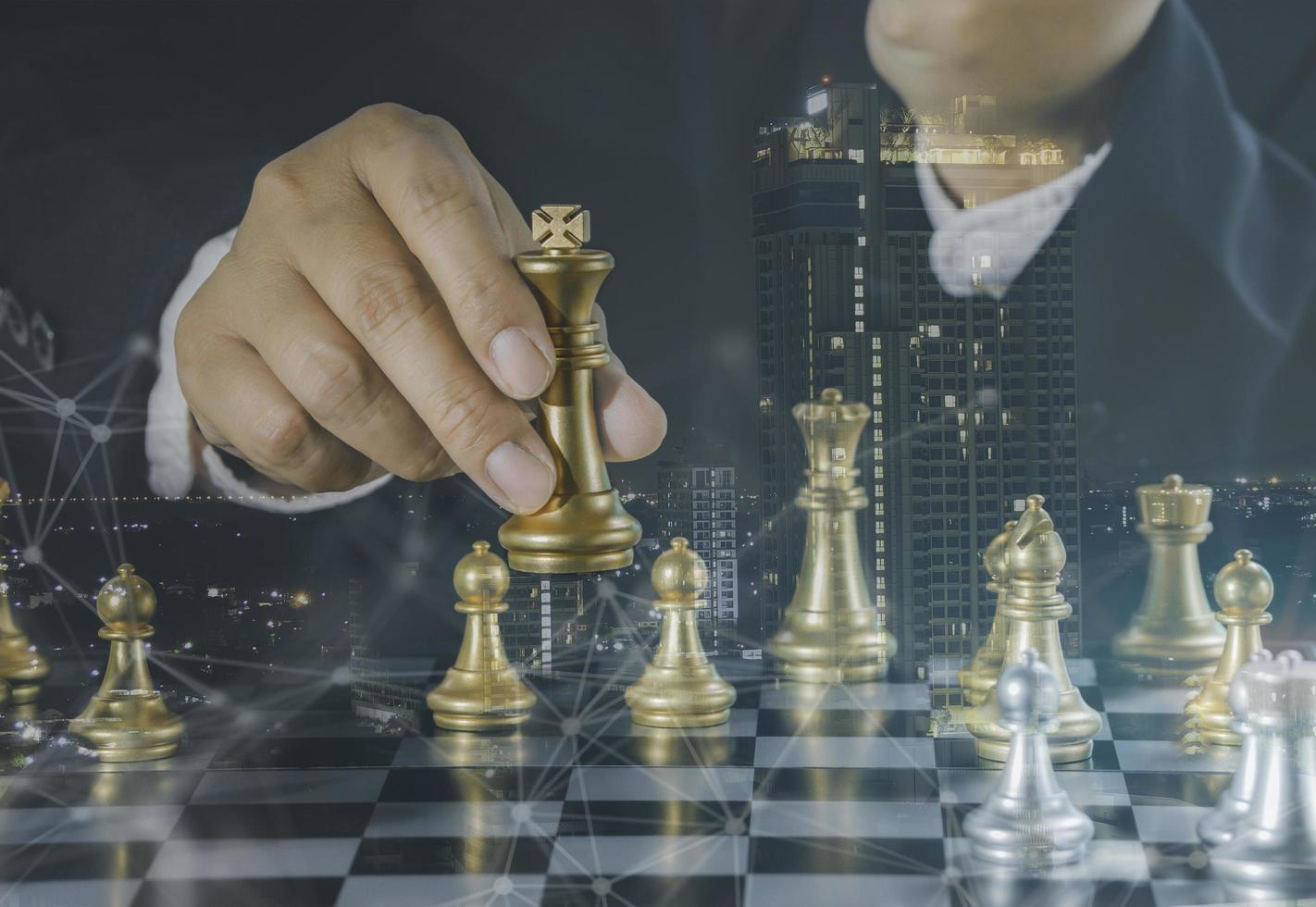 Hand of businessman holding gold king chess on stock market or forex trading graph chart with cityscape image economy trend for digital financial investment.Management or leadership strategy concept. photo