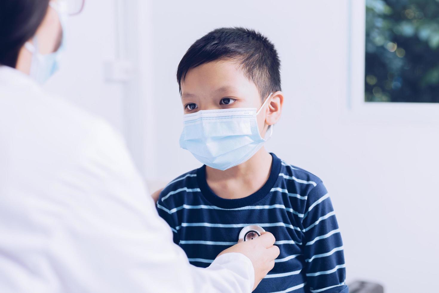 The doctor sits at work, examining a child patient. photo