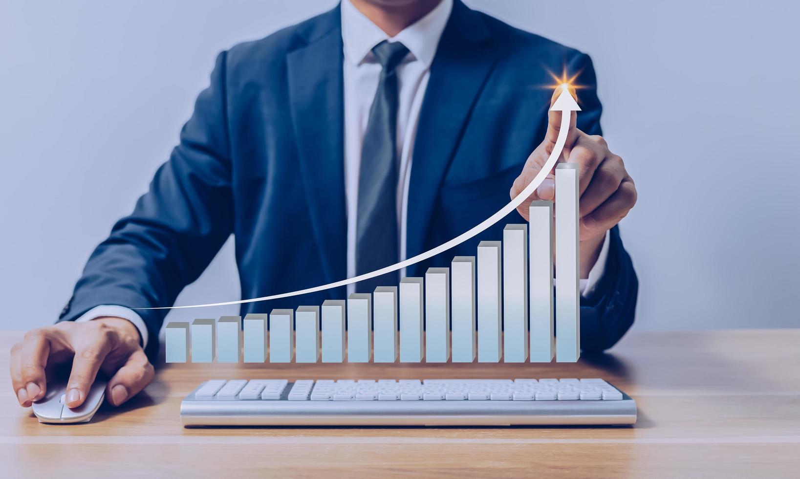 Businessman pointing to virtual investment bar and line graph on wooden table as business strategy and stock value investor concept. photo