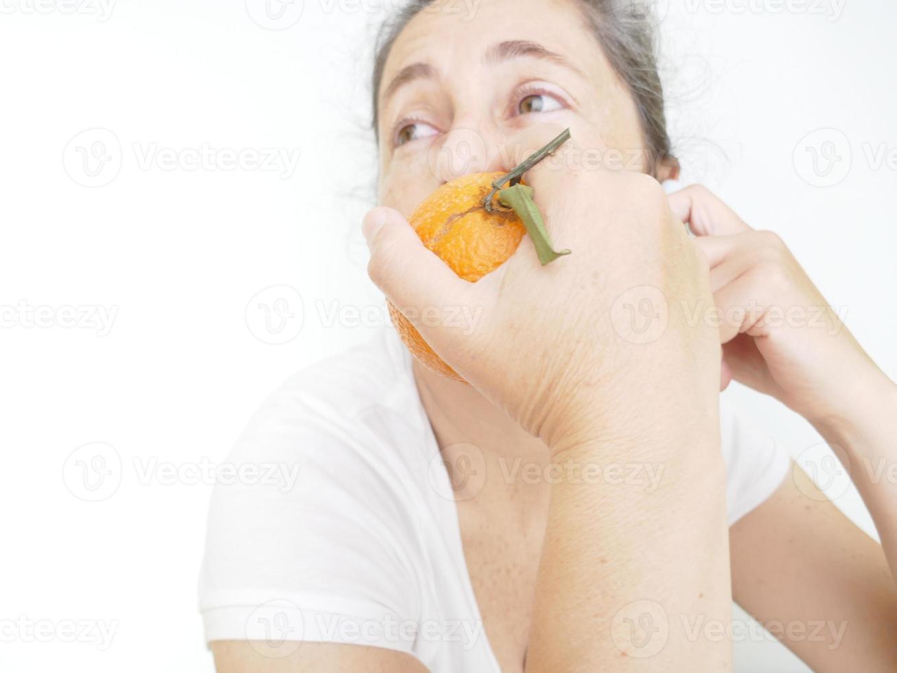 Forty nine year old woman in a white T-Shirt against a white background with an orange photo