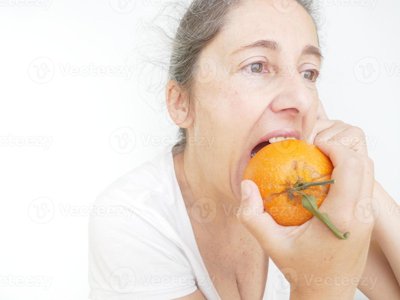 Forty nine year old woman in a white T-Shirt against a white background with an orange photo