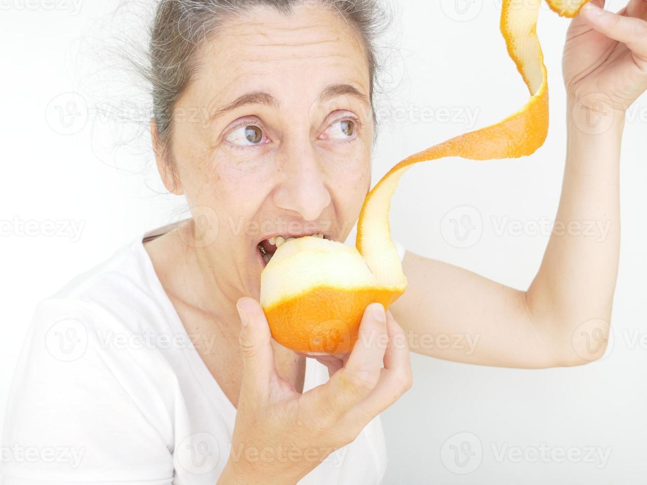 Forty nine year old woman in a white T-Shirt against a white background with an orange photo