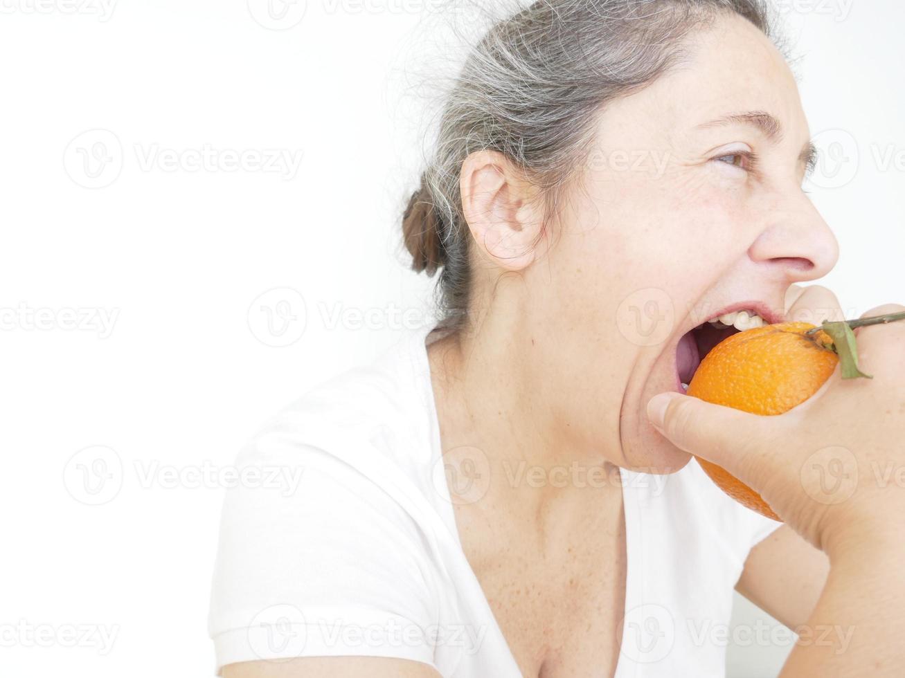 Forty nine year old woman in a white T-Shirt against a white background with an orange photo