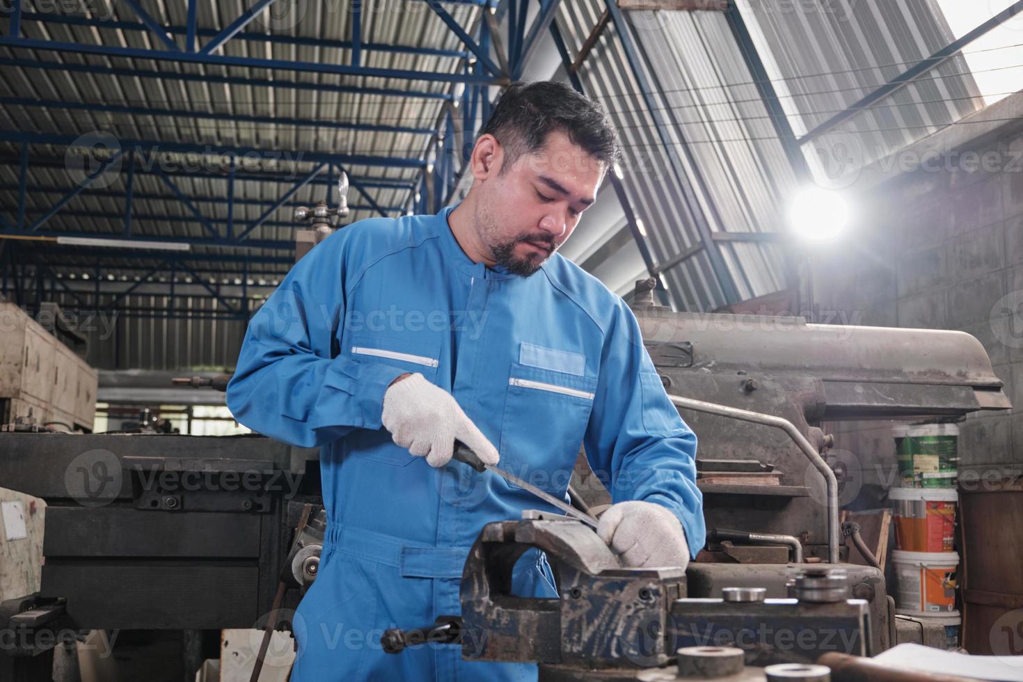 un ingeniero de la industria asiático profesional trabaja con un uniforme de seguridad con herramientas de precisión de metalurgia, máquinas de torno mecánico y taller de piezas de repuesto en la fábrica de fabricación de acero. foto
