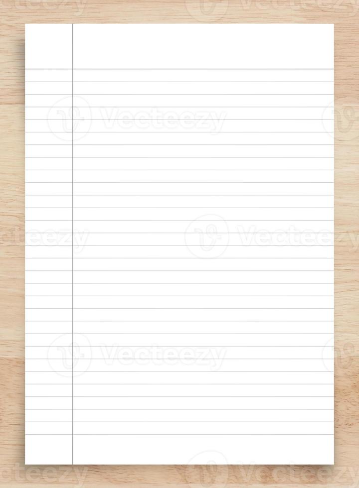 White paper sheet on wood with clipping path. White notebook paper with line pattern background. photo