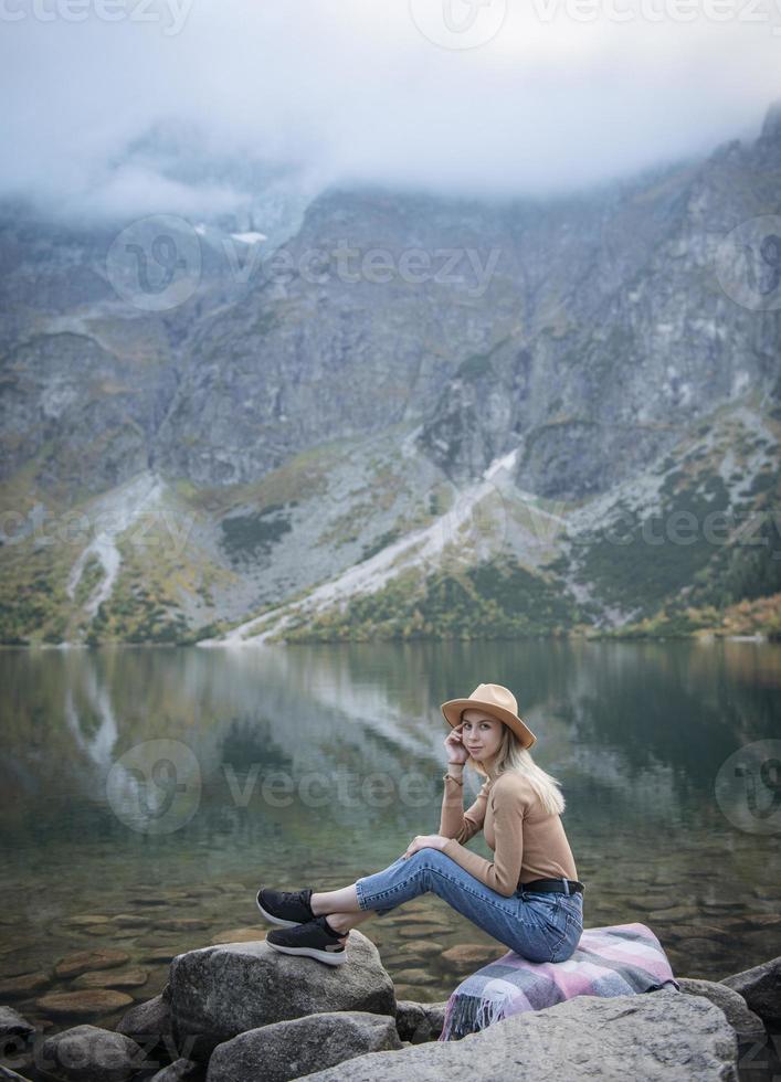 Young woman on a hiking trip sitting on a rock photo