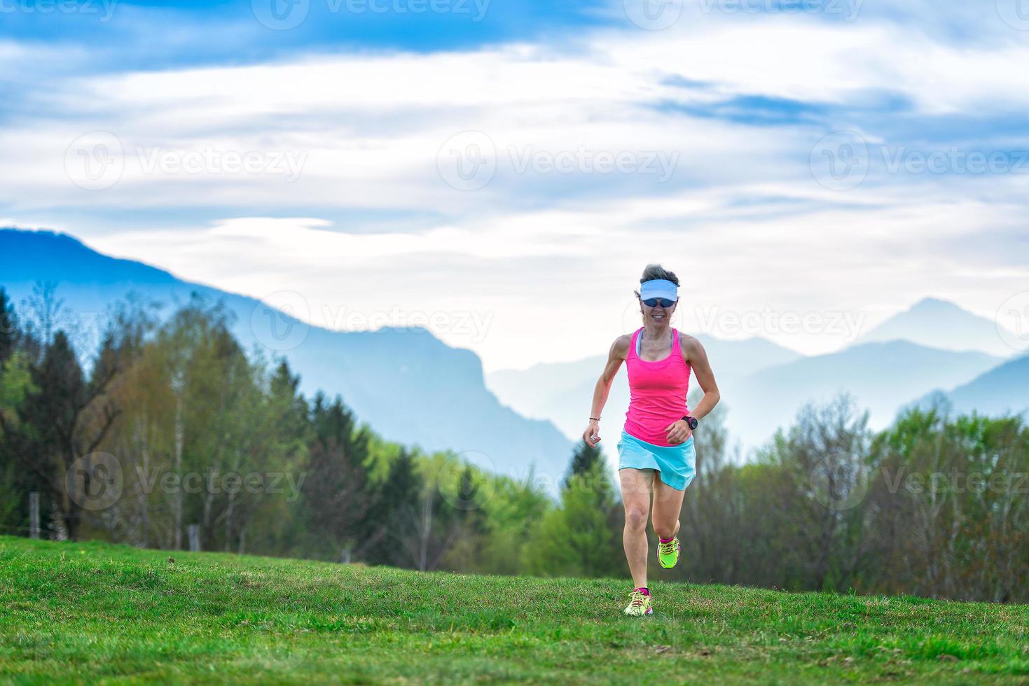 atleta chica rubia corre en las montañas foto