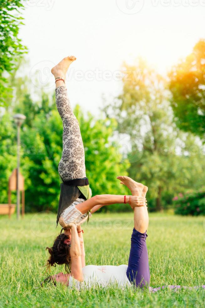 pareja practicando acroyoga en el parque foto